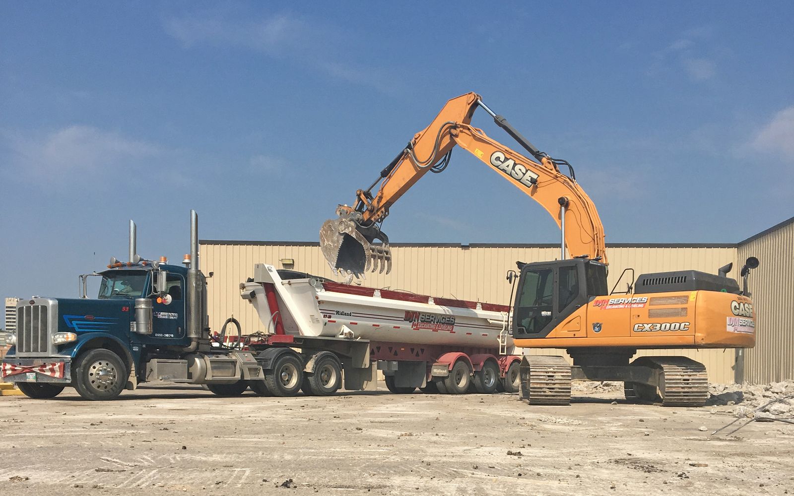 DJN Peterbilt, end dump and excavator loading on site